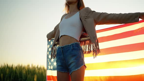 Young Happy Woman Waving USA Stars and Stripes Flag in Golden Sunset Sunshine Field