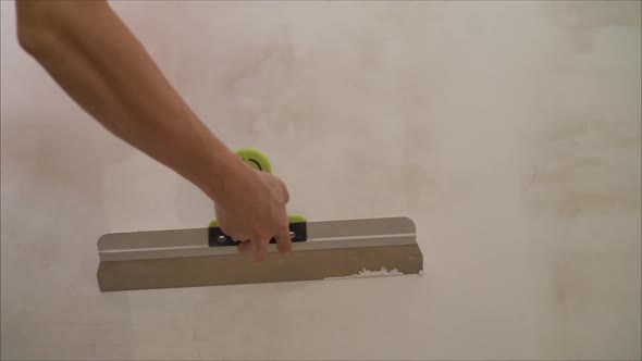 Worker aligns the wall with a spatula