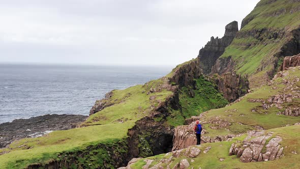 Aerial Back View of Huge Cliffs in Faroe Islands Green Rocky Mountainpowerful Ocean Wavesin a Cloudy