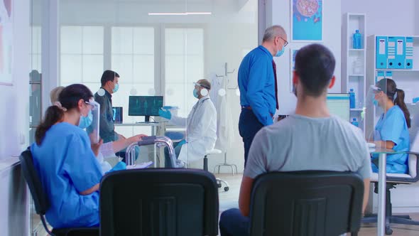 Doctor with Visor and Patient in Examination Room