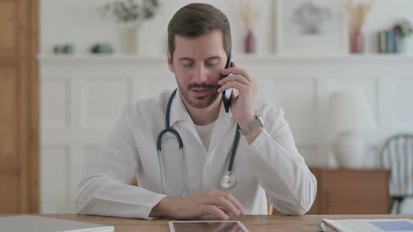 Young Doctor Talking on Phone in Clinic