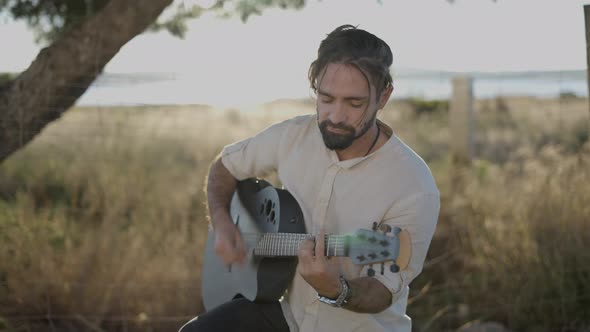 Handsome Man Guitarist Strumming on Classic Acoustic Guitar and Singing Song Looking at Camera Lens