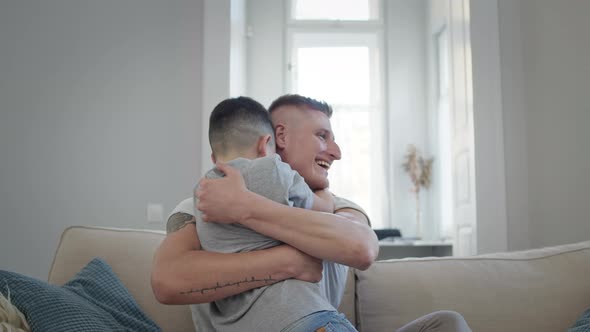 Young Man Sitting On Sofa In Apartment