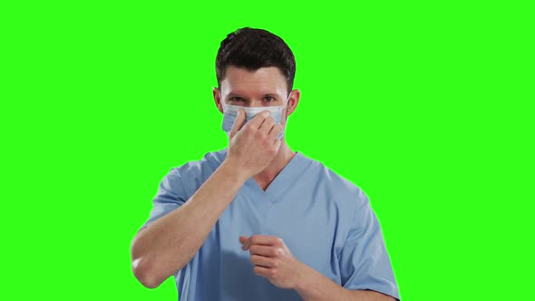 Caucasian male doctor wearing face mask on green screen background