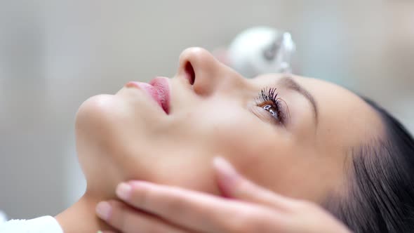 Closeup Face of Confident Pretty Woman During Microdermabrasion Beauty Procedure Using Equipment