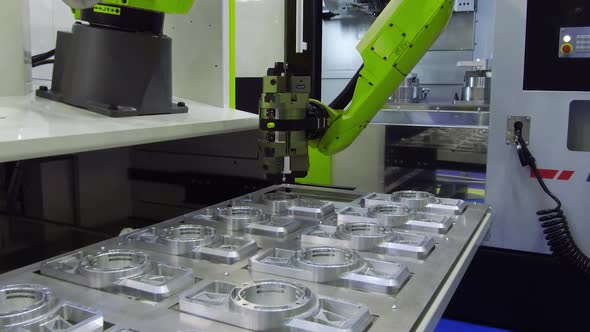 The Robot Arm Sets the Parts for Machining in the CNC Milling Center
