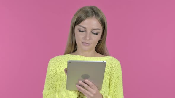 Young Girl Using Tablet and Smiling Pink Background