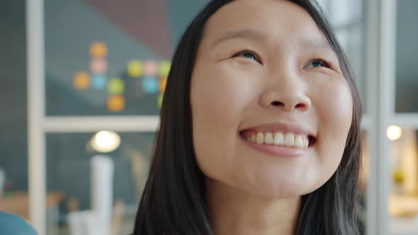 Close-up Portrait of Cute Asian Lady Busiesswoman Looking at Camera in Office