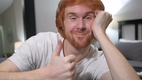 Thumbs Up by Casually Sitting Redhead Man