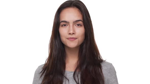 Slow Motion Portrait of Happy Female Model with Long Brown Hair Looking at Camera Smiling Positively