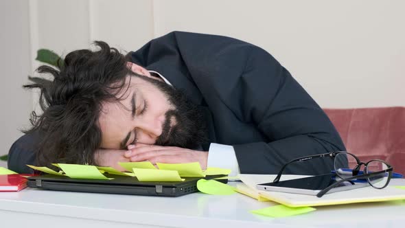 Exhausted and Tired Businessman Sleep with His Head on Computer