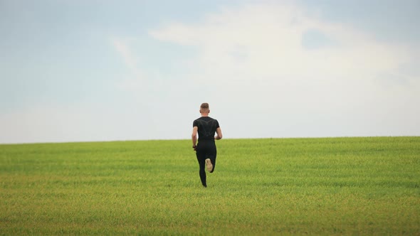 A Sportsman is Quickly Running Across the Green Grass