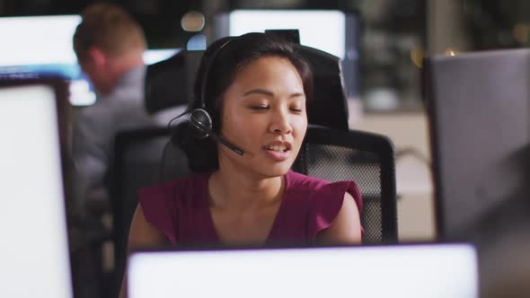 Professional businesswoman smiling while talking on phone headset in modern office in slow motion