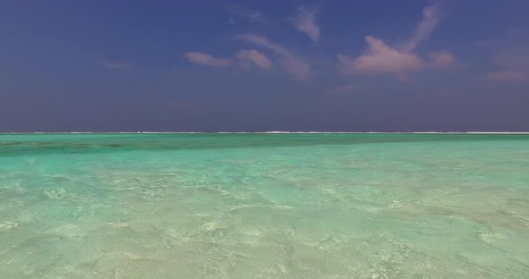 Natural above travel shot of a white sand paradise beach and blue water background in colourful 4K