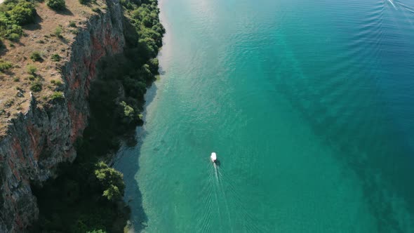 Aerial shot of Macedonia coast. Clif and boat moving on beautiful water around Ohrid Lake in Souther