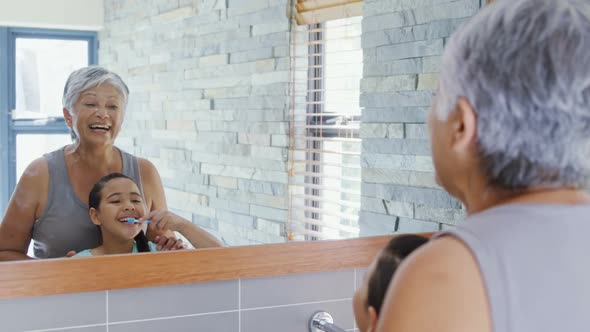 Grandmother and granddaughter brushing teeth in the bathroom 4k