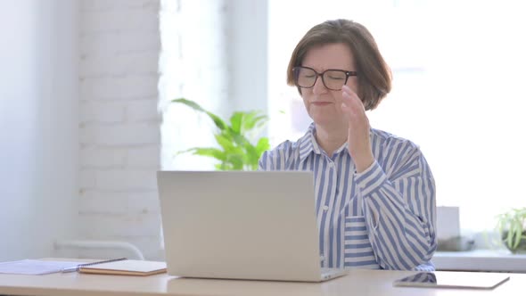 Senior Woman Having Headache While Working on Laptop