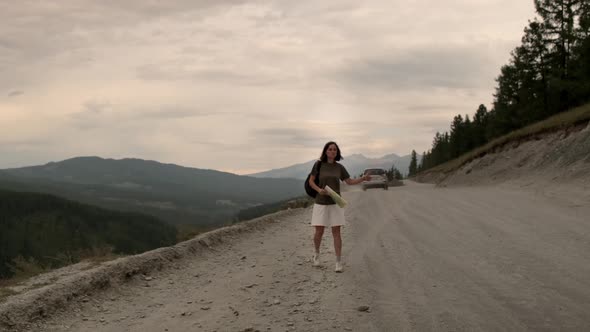 The girl is hitchhiking alone.