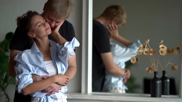 Adult Man Is Hugging His Beautiful Wife From Back in Home, Portrait of Loving Spouses