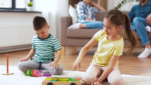 Brother and Sister Playing with Toy Blocks at Home