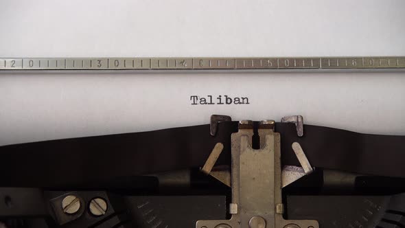 Typing word Taliban on retro typewriter. Close up.