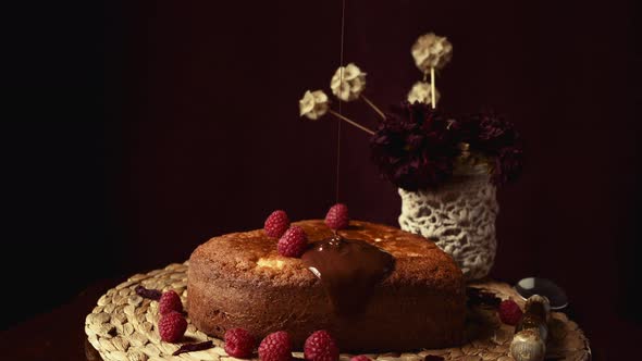 Sweet cake with pouring chocolate topping on wicker placemat