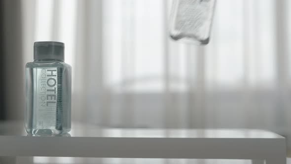 A closeup of three cosmetics bottles being put on a table