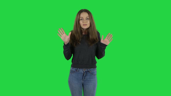 European Young Woman with Brown Hair Is Scolding, Shaking Her Index Finger on a Green Screen