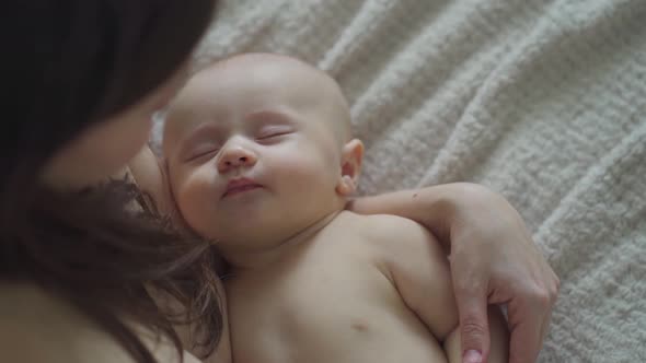 a Beautiful Naked Baby Sleeps in His Mother's Arms