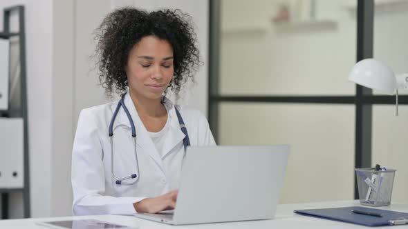 Female African Doctor Smiling While Working Laptop