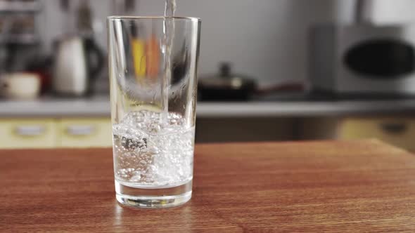 Pure Water is Poured into Transparent Glass The camera Moves Around the Table in the kitchen