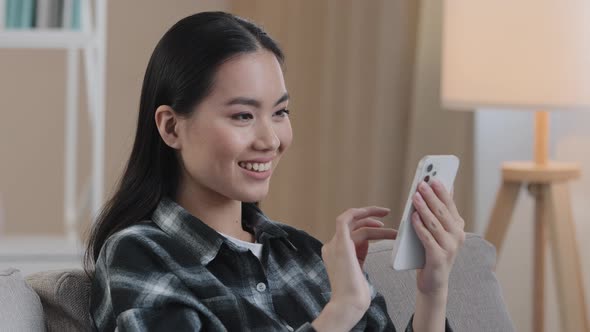 Smiling Happy Asian Woman Typing Swipe Touchscreen of Phone Korean Girl Cheerful Choosing Shopping