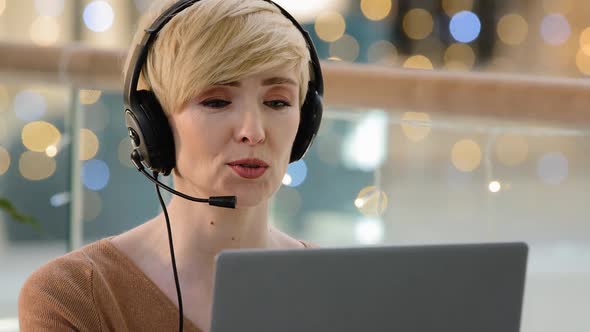 Front View Head Shot Middle Aged Adult 40s Woman in Headset Microphone Looking at Web Camera on