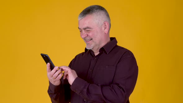 Handsome adult man uses smartphone texting messages in social media