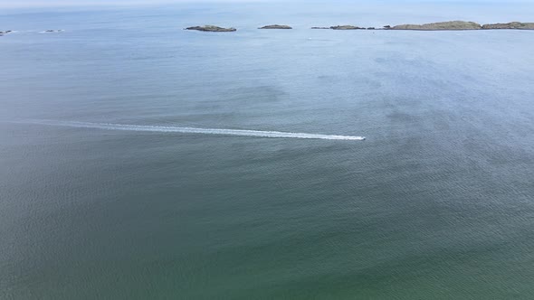 A Speedboat Swiftly Moving Across Big Blue Sea In Ireland With Volcanic Island In The Background - a