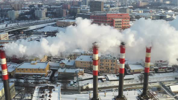 In the winter city, the factory's chimneys are smoking. The concept of air pollution. 