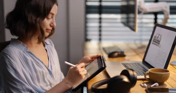 Woman Working on a Digital Tablet in Home Office