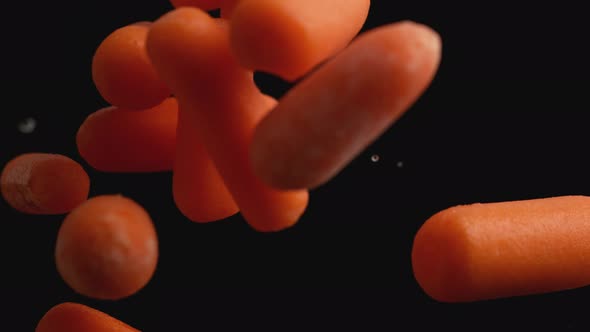 Camera follows throwing carrots into water. Slow Motion.