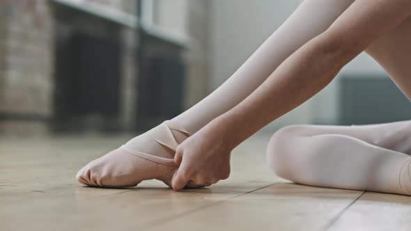 Little Ballerina Tying Pointe Shoes Before Training