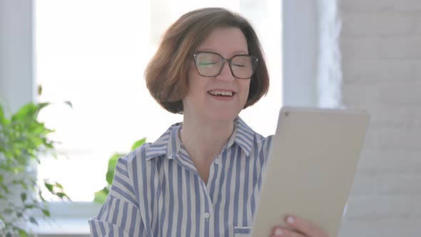 Portrait of Video Call on Tablet By Senior Woman in Office