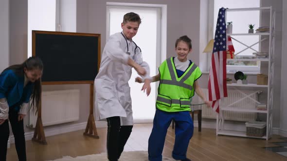 Hyperactive Teenage Boys and Girl Having Fun Dancing Indoors at Home