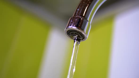 Water Running From the Tap Into a Sink