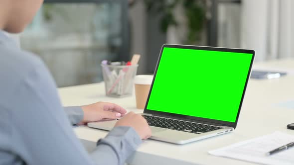 Rear View of African Woman Using Laptop with Green Chroma Key Screen