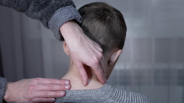 Hands of the Masseuse Makes Massage the Cervical Spine of the Child at Home