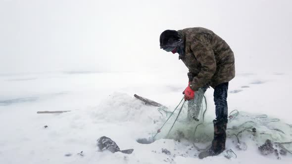 Fishing From Frozen Lake in Harsh Weather