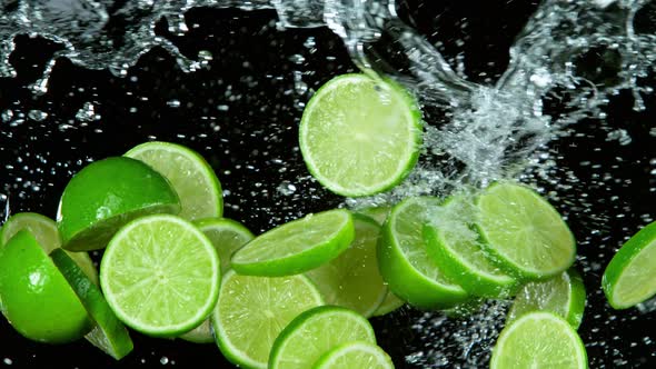 Super Slow Motion Shot of Flying Fresh Lime Slices and Water Side Splash Isolated 1000Fps