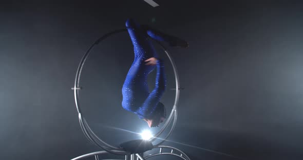 Young Lady in Blue Costume is Doing Upside Down Poses in a Hoop Gymnastics