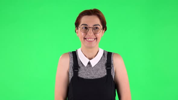 Portrait of Funny Girl in Round Glasses Is Waiting in Anticipation with Pleasure. Green Screen