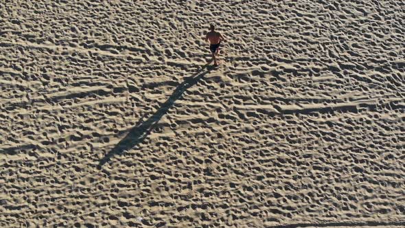 Young Man Jogging on the City Beach