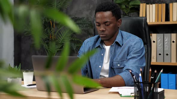 Adult African American Man Freelancer Works for Laptop Typing Text on Keyboard